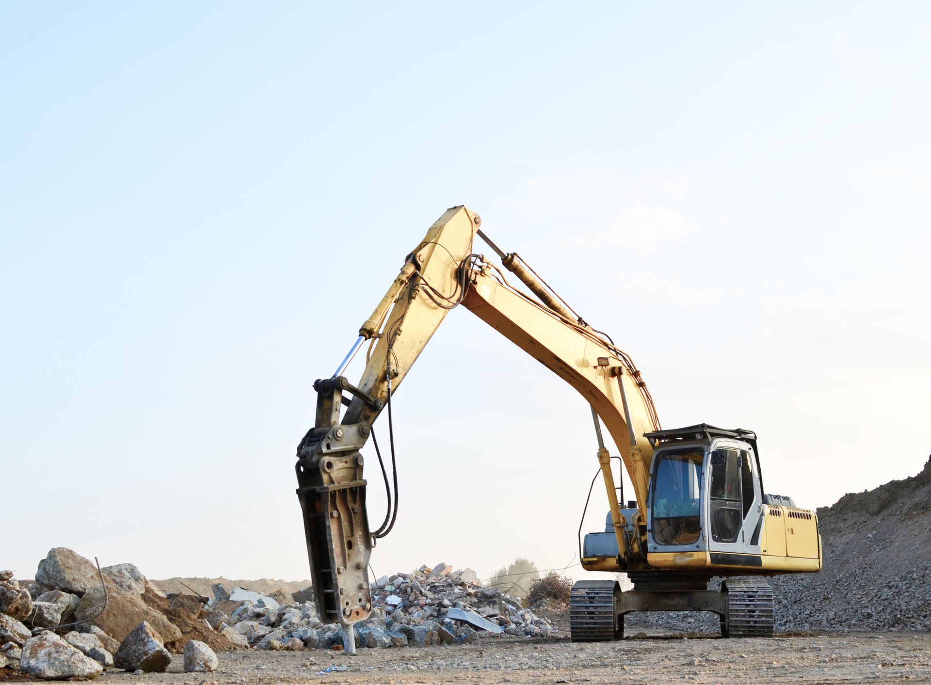 Ein großer Bagger arbeitet an einem Felsenhaufen